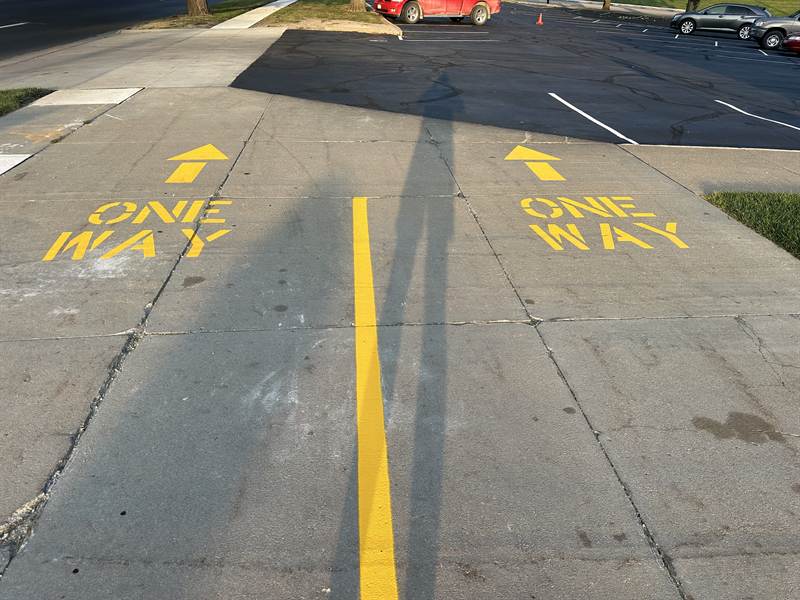 Freshly painted ONE WAY directional stencils with arrows on pavement
